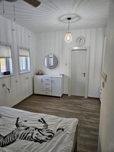 a bedroom with a bed and a clock on the wall at private house near Jerusalem in Beit Shemesh
