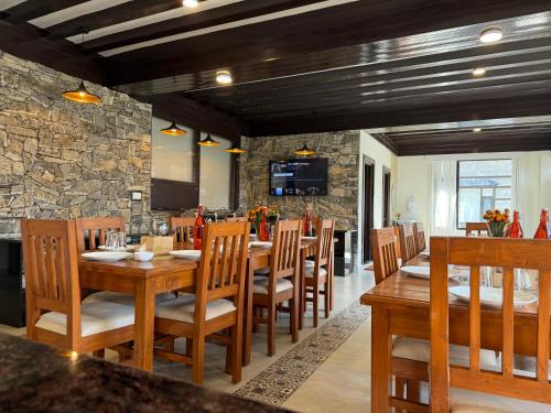 a dining room with a table and wooden chairs at Manali Se - Your Home in the Pines in Jagatsukh