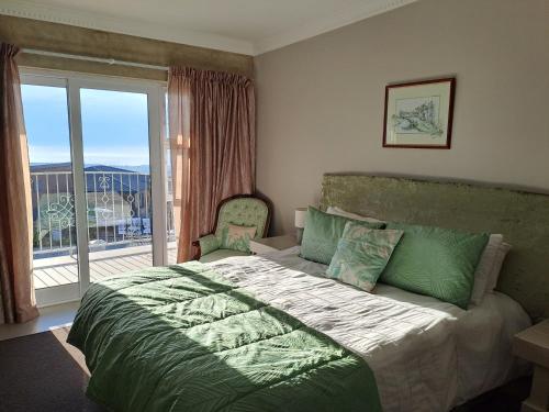 a bedroom with a bed and a large window at Stone Crown Manor B&B in Mossel Bay