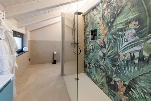 a bathroom with a shower with a mural of flowers at La Collina delle Rondini in Boves