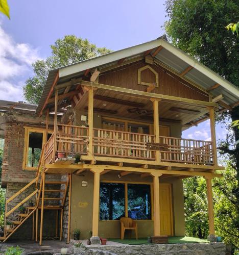 a house with a wrap around porch with a deck at Tiny house soyal in Kulu