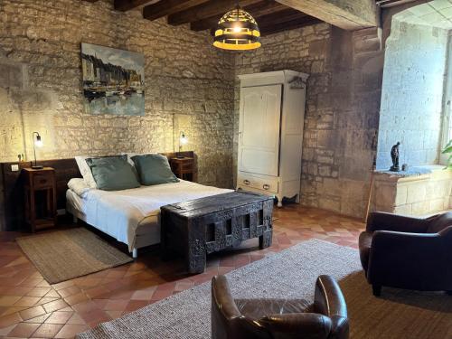 a bedroom with a bed and a couch and a chair at Château de Bagneux in Bournan