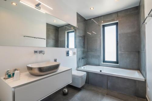 a bathroom with a sink and a tub and a toilet at Villa Miragem Alvor in Alvor