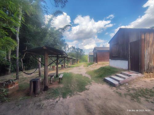 an outdoor area with a bench and a pavilion at Pousada Sítio do Aconchego Porto Feliz in Pôrto Feliz