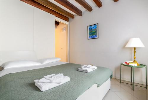 a bedroom with a bed with towels on it at Erbe Canal View Private House in Venice