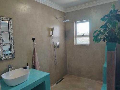 a bathroom with a white sink and a window at Stone Crown Manor B&B in Mossel Bay
