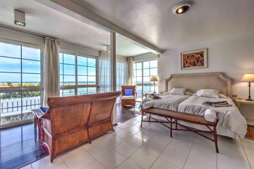 a bedroom with a bed and large windows at Seafront villa with jacuzzi in Maspalomas