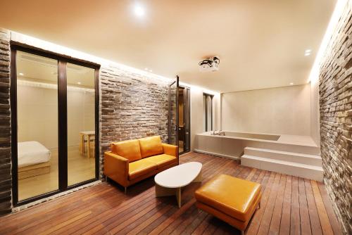 a room with a bed and a couch and a chair at 브라운도트호텔동탄역점 구 js더클래식호텔 in Hwaseong