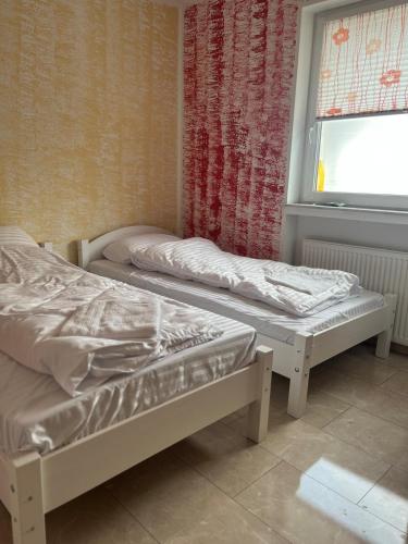 two beds in a room with a window at Ferienwohnung Fatlume No 4 in Bad Honnef am Rhein
