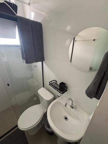 a bathroom with a toilet and a sink and a mirror at Smart Studio Lavras in Lavras