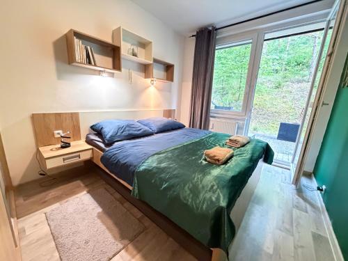 a bedroom with a bed and a large window at KaiTea Suites in Všemina
