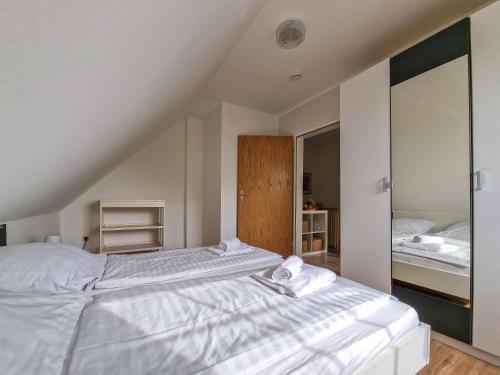 a bedroom with two beds with white sheets at Wolles Sonnenhaus in Wirdum