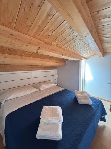 a large bed in a room with a wooden ceiling at Veterani House 33 in Cefalù