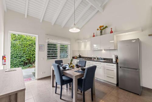 a kitchen with a table and chairs and a refrigerator at Casa Verde - Blije Rust I in Dorp Sint Michiel