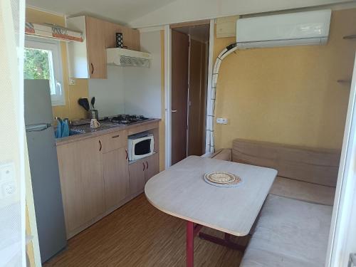a small kitchen with a table in a small room at Mobile homes a la ferme in Ille-sur-Têt