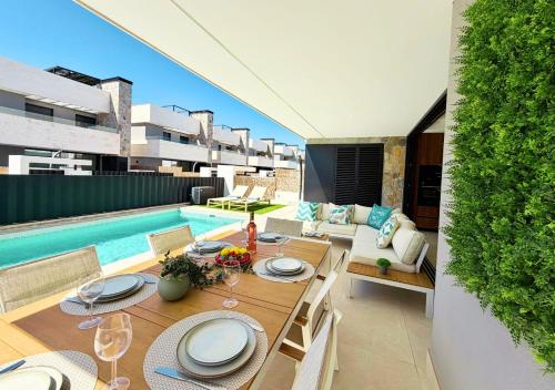 a patio with a table and chairs and a pool at LUXURY VILLA ALMENDRO 15 WITH PRIVATE HEATED POOL at SANTA ROSALIA RESORT by PREMIUM SPAIN PROPERTIES in Torre-Pacheco