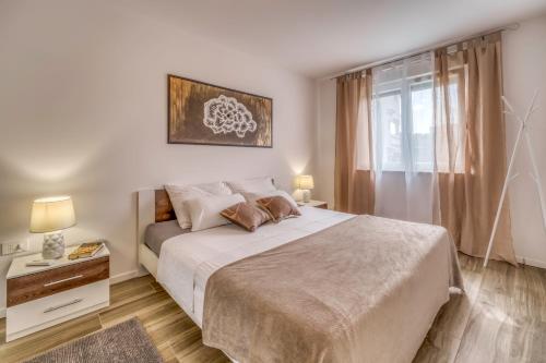 a bedroom with a large bed and a window at Apartments Doris in Malinska