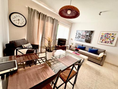 a living room with a table and a clock on the wall at Departamento Corriquia in Playa Blanca