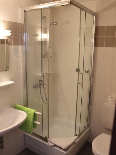 a shower with a glass door in a bathroom at Osterberg - Restaurant und Hotel in Hildesheim