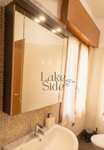 a bathroom with a sink and a large mirror at Bijou - Lake side apartments in Sandra