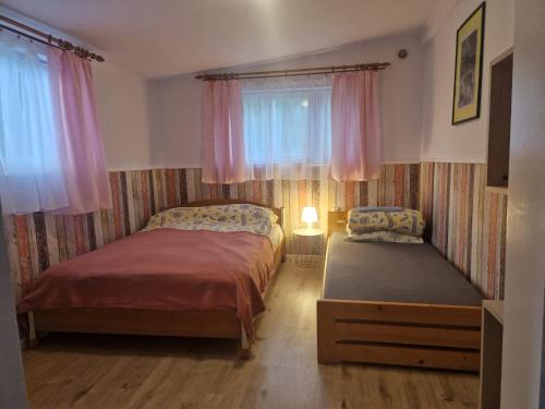 a bedroom with two beds and a window at Mazury - Ruś domki wypoczynkowe nad samym jeziorem in Ruś