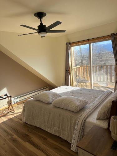 a bedroom with a bed with a ceiling fan and a window at YellowstoneMigrant in Emigrant