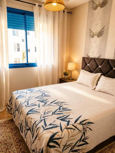 a bedroom with a large bed and a window at Perla Andalusia Bright 2BR Near Beach & Pool in Mansouria