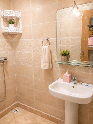a bathroom with a sink and a mirror at Perla Andalusia Bright 2BR Near Beach & Pool in Mansouria