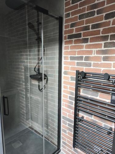 a glass shower stall in a brick wall at Escale à Clisson - l'Hippo Loft in Clisson