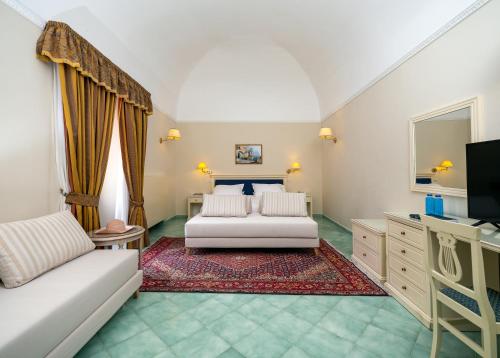 a living room with a couch and a tv at Hotel Iaccarino in SantʼAgata sui Due Golfi
