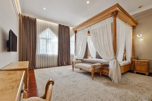 a bedroom with a canopy bed and a chair at Ichan Qal'a Premium Class Hotel in Tashkent