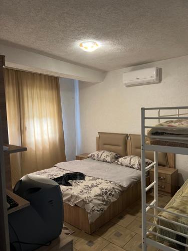 a small bedroom with a bed and a desk at Villa Gryka in Peje