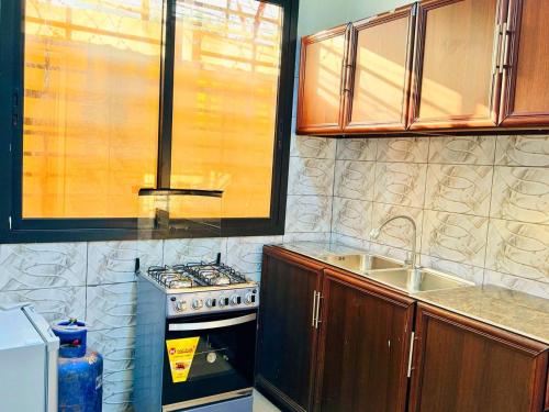 a kitchen with a stove and a sink at Prestige A4 in Ouagadougou