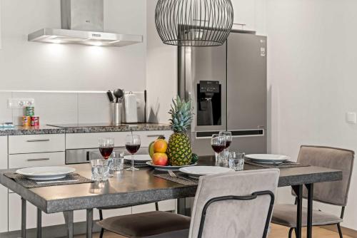 a kitchen with a table with wine glasses and a pineapple at Apartamento Sorbos in Dorp Sint Michiel