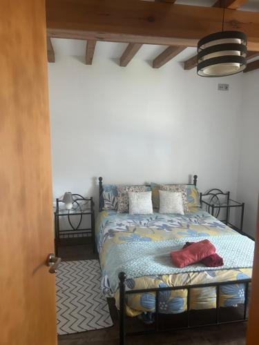 a bedroom with a bed with a blue comforter and pillows at El Descanso Lastres in Colunga