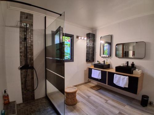 a bathroom with two sinks and a shower at La Varangue in La Possession