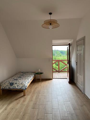 a bedroom with a bed and a door to a balcony at Agroturystyka Borów - pokoje in Prusice