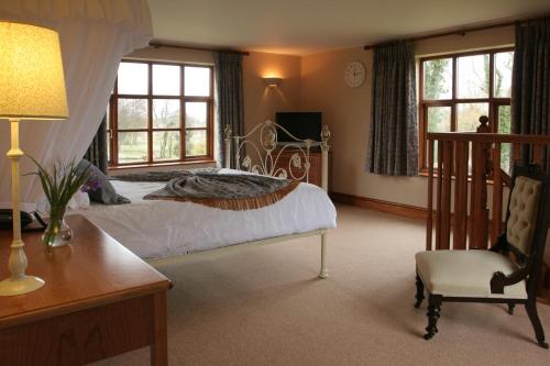 a bedroom with a bed and a desk and a chair at Ivy House Country Hotel in Lowestoft