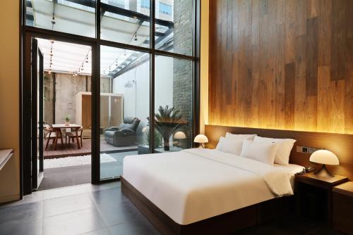 a bedroom with a large bed and a large window at 브라운도트호텔동탄역점 구 js더클래식호텔 in Hwaseong