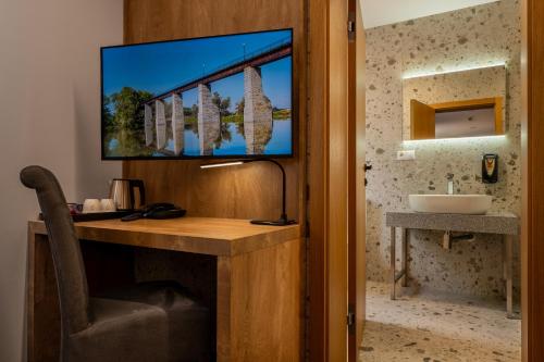 a room with a desk with a sink and a mirror at Hotel Novy Kastiel - Self check-in in Topoľčany