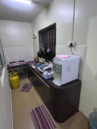 a kitchen with a counter top with a microwave at Labis Homestay Afina in Labis