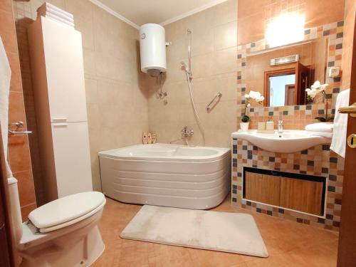 a bathroom with a tub and a toilet and a sink at 2Hearts Apartment - Medjugorje in Međugorje