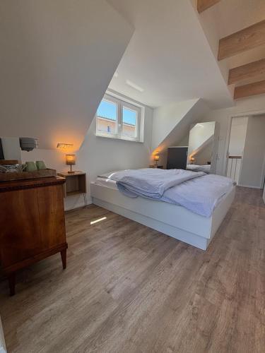 a bedroom with a bed and a wooden floor at Timmendorfer Herz in Timmendorfer Strand