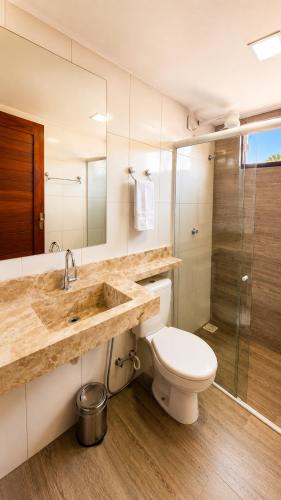 a bathroom with a sink and a toilet and a shower at Pousada Hope Club in Beberibe