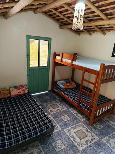 a room with two bunk beds and a green door at la embajada hospedaje in San Rafael