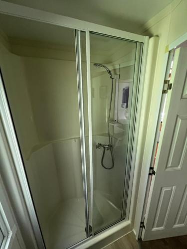 a shower with a glass door in a bathroom at Devon Tor View Country Retreat in Bratton Clovelly