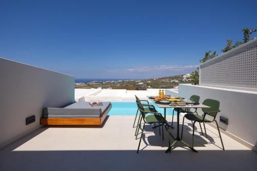 a patio with a table and chairs and a pool at Evira Suites in Pyrgos