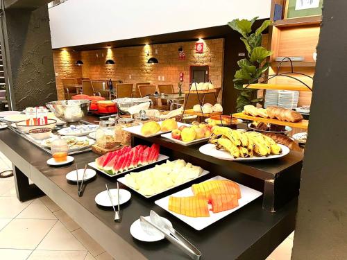 a buffet line with many different types of food at Oasis Tower Hotel in Ribeirão Preto