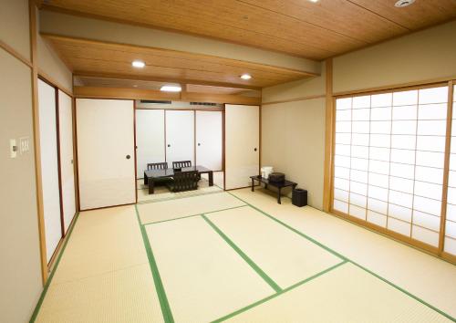 an empty room with large windows in a room at Ariston Hotel Kobe in Kobe