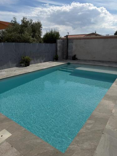 a swimming pool with blue water in a backyard at Casa Puerta de Toledo, a 8 minutos de Puy du Fou in Cobisa